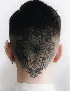 the back of a man's head with an intricate tattoo on his forehead and neck