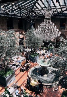 an overhead view of people sitting at tables in a restaurant with chandelier hanging from the ceiling