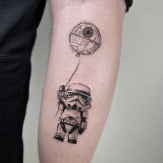 a star wars character holding a balloon tattoo on the right forearm and arm, while wearing a helmet