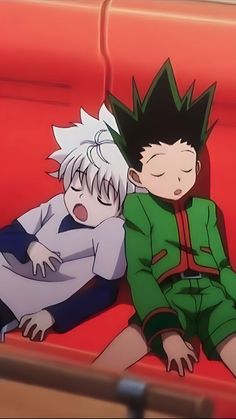 two anime characters sitting on a red couch