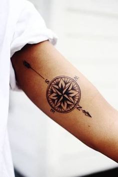 a person with a compass tattoo on their arm