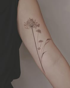 a woman's arm with a flower tattoo on the left side of her arm