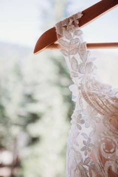 a white dress hanging on a wooden hanger