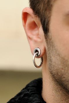 a close up of a person wearing some kind of silver earring on their left ear