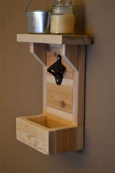 a wooden shelf with a candle holder on it and a metal container hanging from the wall