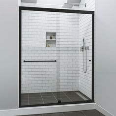 a bathroom with a walk in shower next to a white wall and tiled flooring