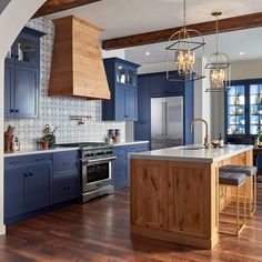 a kitchen with blue cabinets and wooden floors