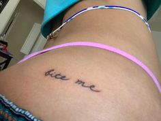 a woman's lower back with the word bite me written on it