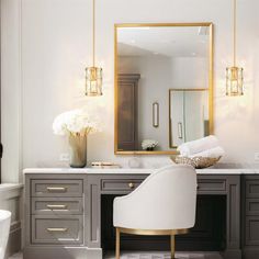 a white chair sitting in front of a bathroom vanity next to a mirror and sink