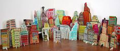 a group of paper city buildings on a wooden floor