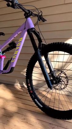 a purple and black mountain bike parked in front of a house