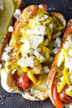 two hot dogs with onions and relish on them