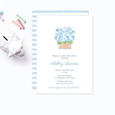 a blue and white baby shower is next to it's birth announcement card, with toothbrushes on the table