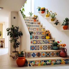 the stairs are decorated with colorful tiles and potted plants