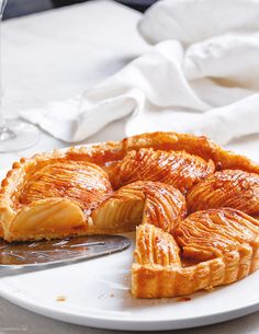 a pastry on a white plate with a knife and glass of wine in the background