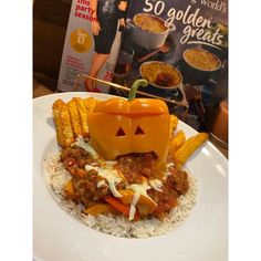 a white plate topped with fries and a jack - o'- lantern on top of it