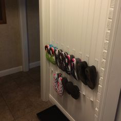 there are many pairs of shoes hanging on the wall next to each other in this hallway