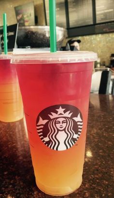 two drinks sitting on top of a table next to each other in front of a counter