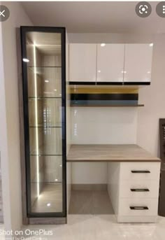 an office with white cabinets and drawers in the middle of it, next to a glass display case