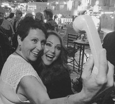 two women taking a selfie with an object in their hand at a bar or restaurant