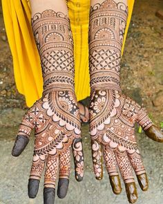 two hands with henna designs on them