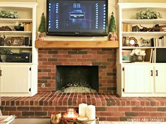 a living room with a fire place and television on the wall above it's fireplace