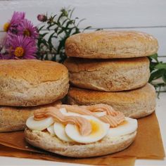 some eggs and bacon are stacked on top of each other, with flowers in the background