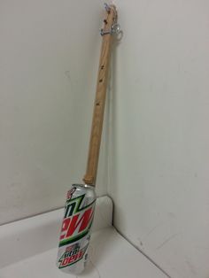 a wooden stick sticking out of the side of a wall next to a can of diet coke