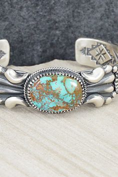 This stunningly detailed, turquoise and sterling silver bracelet was made by Navajo silversmith Delbert Gordon. The inside is signed D. Gordon and stamped Sterling and Navajo.Size: 5 1/2" (will fit up to a 6 1/2" wrist)Gap: 1"Width: 3/4"Free shipping on all orders! We ship with USPS and always include tracking. All orders ship within a day of payment.Returns are accepted up to 30 days after you receive your order. Just send us a message. Our shop offers cash back or store credit. The item must b Handmade Southwestern Sterling Silver Bracelet, Southwestern Style Stamped Turquoise Bracelets, Western Turquoise Bracelet With Patina, Southwestern Style Turquoise Stamped Bracelets, Western Silver Bracelet With Patina, Western Style Turquoise Stamped Bracelets, Southwestern Stamped Turquoise Sterling Silver Bracelet, Southwestern Turquoise Stamped Sterling Silver Bracelet, Southwestern Style Sterling Silver Turquoise Bracelet