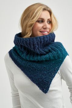 a woman wearing a blue and green knitted cowl with a scarf around her neck