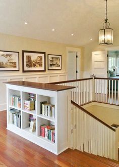 an open floor plan for a home with stairs and bookshelves in the living room