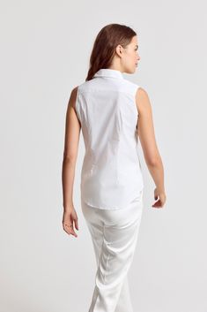 Our warm weather cotton staple. The Sleeveless Shirt is a classic for layering or to wear on its own. Narrow armholes mean bra won't peek through the side (and won't peek through the front either). Rochelle Behrens reimagined how shirts should fit and feel. Our patented No Gape® button technology, seamlessly designed into every shirt and shirtdress we design, eliminates blouse gape. Finally say bye bye blouse gape, hello The Shirt. 75% Cotton, 20% Nylon, 5% Stretch Made In Portugal Powered by ou Classic Cotton Tank Top For Work, Classic Cotton Sleeveless Tank Top, Classic White Tank Top For Daywear, Fitted Vest Top For Daywear, Classic Cotton Vest Top, Classic Cotton Tank Top For Daywear, Classic Summer Vest Tops, Cotton Tank Top For Workwear, Classic Sleeveless Tank Top For Summer