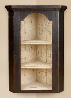 an old wooden shelf with shelves on the top and bottom, in front of a wall