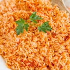 a white bowl filled with rice and garnished with parsley