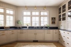 a large kitchen with white cabinets and black counter tops, along with an area rug on the floor