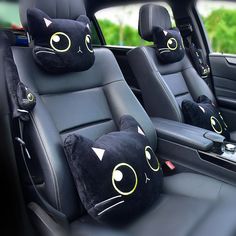 two black cats pillows sitting on the back seats of a car