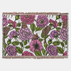 a pink and purple flowered tapestry hanging on a white wall with green leaves around it