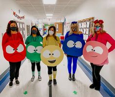 four women in costumes are standing on the hallway with masks covering their faces and mouths