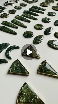 a white table topped with lots of green leafy shapes on top of each other