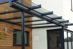 an outdoor patio area with wooden walls and black metal bars on the side of it