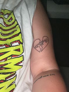 a person with a heart tattoo on their arm