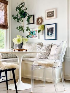 a living room filled with furniture next to a white table and two clear chairs in front of a window