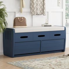 a blue bench with two drawers and a handbag on it in front of a white wall