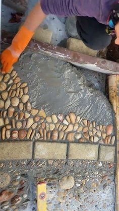 a woman is working on some kind of stone work in the process of being built