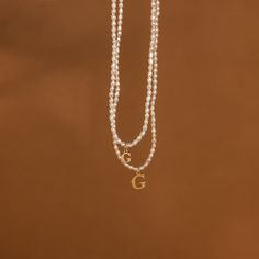 Our Pearl Initial Necklace embodies both elegance and fun. The customizable letter charm allows for a personal touch to a classic dainty pearl necklace. Wear this everyday minimalist jewelry piece to brunch with friends and then to a fancy dinner date at night. Material: High Quality Solid 925 Sterling Silver Finish: Sterling Silver ∙ 18K Gold ∙ Rose Gold Dimensions: Choose between two charm sizes ~7mm or ~12mm SKU: MM-NM114F33 Fancy Dinner Date, Dainty Pearl Necklace, Dainty Diamond Necklace, Rose Gold Charms, Letter Charm, Fancy Dinner, Dinner Date, Initial Jewelry, Station Necklace