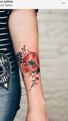 a woman's arm with a red flower tattoo on it