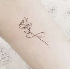 a woman's arm with a small tattoo on it