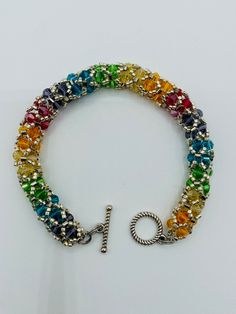 8.5 inches in length. Rainbow Fire Polished Flexible Bracelet. Made with Czech Glass Fire Polished Glass and Delica Beads. Stainless Steel Double Jump rings and Toggle Clasp. Multicolor Crystal Bracelet With Jubilee Style And Round Beads, Multicolor Jubilee Crystal Bracelet With Round Beads, Rainbow Faceted Beads Bracelet For Jewelry Making, Multicolor Metal Bracelets With Round Beads, Multicolor Beaded Metal Bracelets, Nickel-free Multicolor Beaded Bangle Bracelets, Beaded Metal Crystal Bracelet, Nickel-free Multicolor Beaded Bracelets, Nickel Free Multicolor Beaded Bracelets