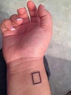 a small square tattoo on the wrist