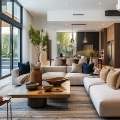 a living room filled with lots of furniture and large glass doors leading to an outside patio